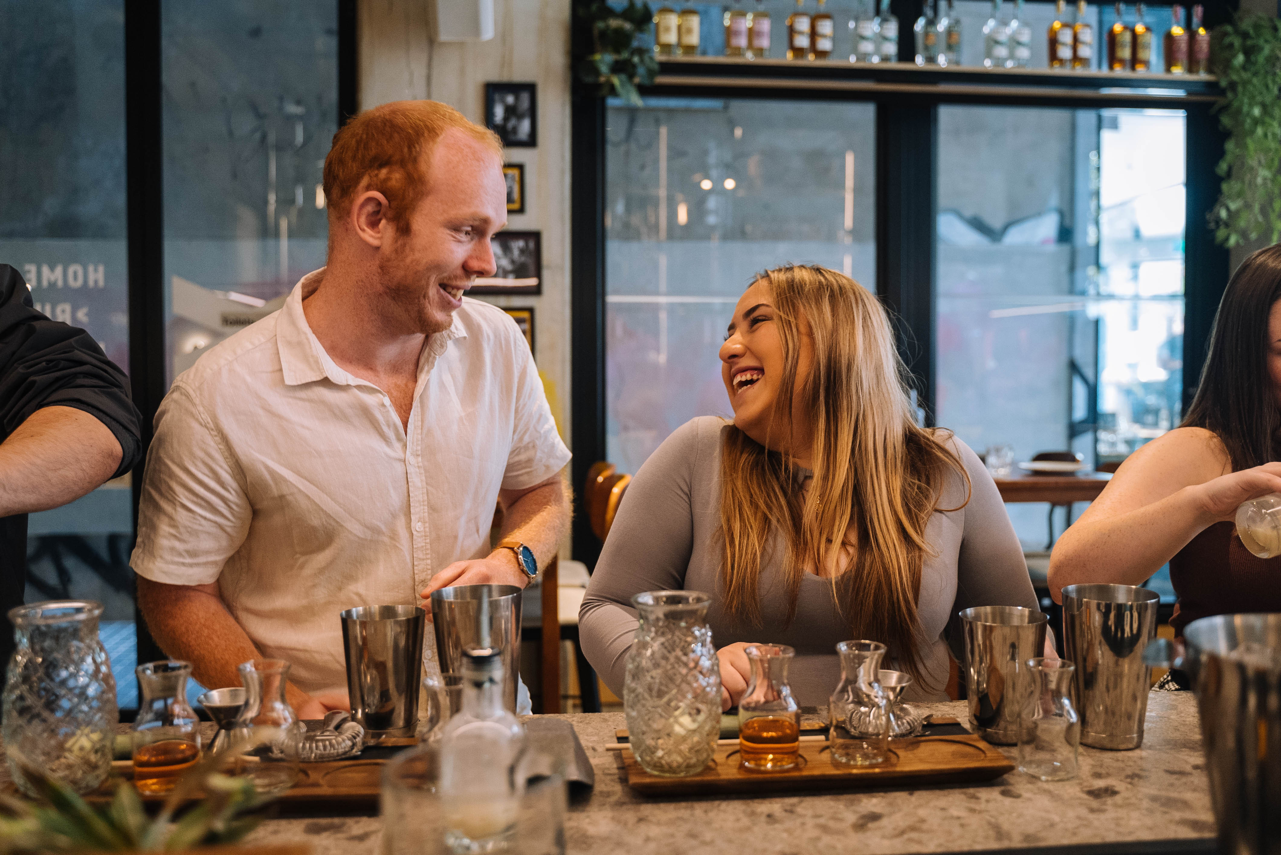 Man and a woman making cocktail at a cocktail class 